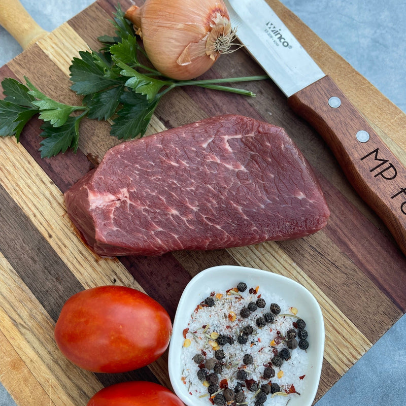raw denver steak with herbs and tomatoes