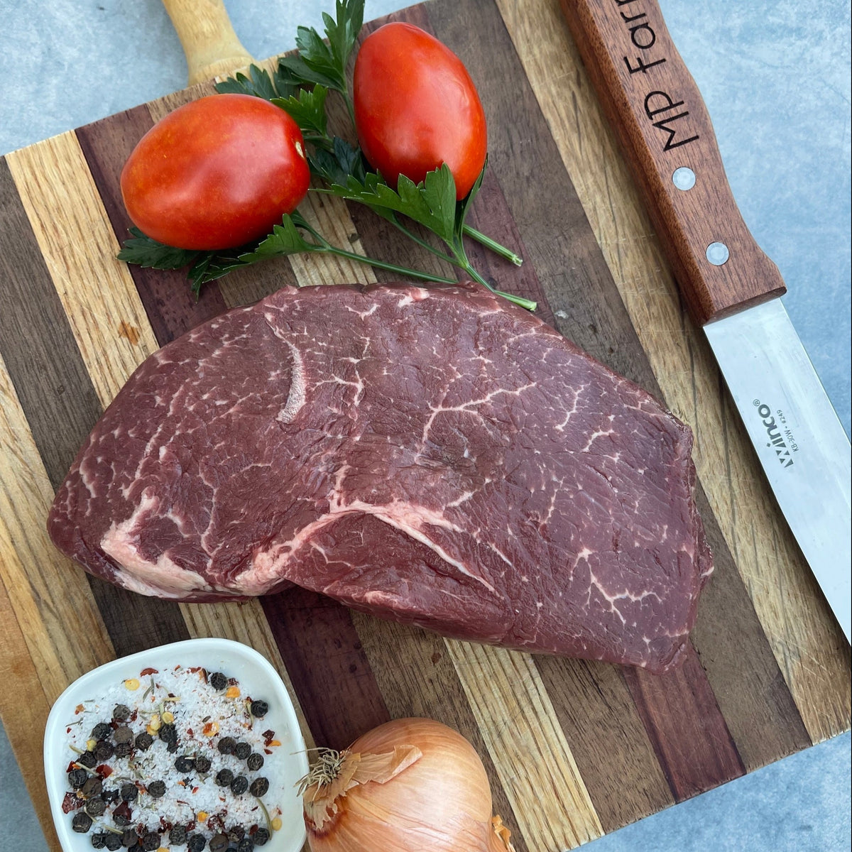 raw sirloin steak with herbs and tomatoes